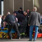 Juneau first responders lift a woman into a stretcher after she reportedly shot herself in front of the main entrance of the Dimond Courthouse on Monday.