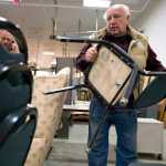 Roger Sams stacks chairs he plans to buy during the State of Alaska surplus sale Wednesday morning.