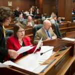 Rep. Lynn Gattis, R-Wasilla, left, talks with Rep. Tammie Wilson, R-North Pole, as the House of Representatives works on the state operating bill at the Capitol on Thursday.