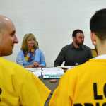 Lemon Creek Correctional Center inmate James Hillyer, left, and other inmates listen as Glory Hole Shelter employee Trevor Kellar, second from the right, talks about how to secure housing after being released from prison. Kellar was one of several community members present at the Prison's annual Success Inside and Out conference, which took place Saturday.