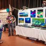 Owner and photographer of Alaska Imagery talks with a Home Expo attendee drawn by his art work.