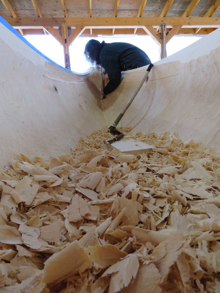 Zack (Tlél Tooch Tláa.aa) James works on the inside of the first of two 40-foot spruce dugout canoes in Hoonah.