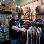 John Delgado goes through his Pendleton wool shirts Monday in his Urban Eskimo shop at its new location across Seward Street from his former location. Delgado has run his shop for 11 years.