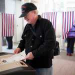 Dr. Johnny Holland feeds his ballot into a counting machine while voting during Juneau's special mayoral election Tuesday at the Mendenhall Valley Public Library.