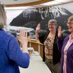 Juneau Municipal Clerk Laurie Sica, left, swears in City Manager Kim Kiefer, center, and Assistant City Manager Mila Cosgrove to be election workers so they could help count questioned ballots from Tuesday's special mayoral election in the Assembly Chamber on Friday.