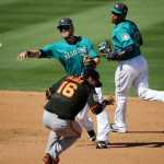 Seattle Mariners shortstop Shawn O'Malley, center, throws the ball to first base after forcing out San Francisco Giants' Angel Pagan as teammate Robinson Cano, right, helps cover second base during a spring training baseball game on March 16 in Peoria, Arizona.