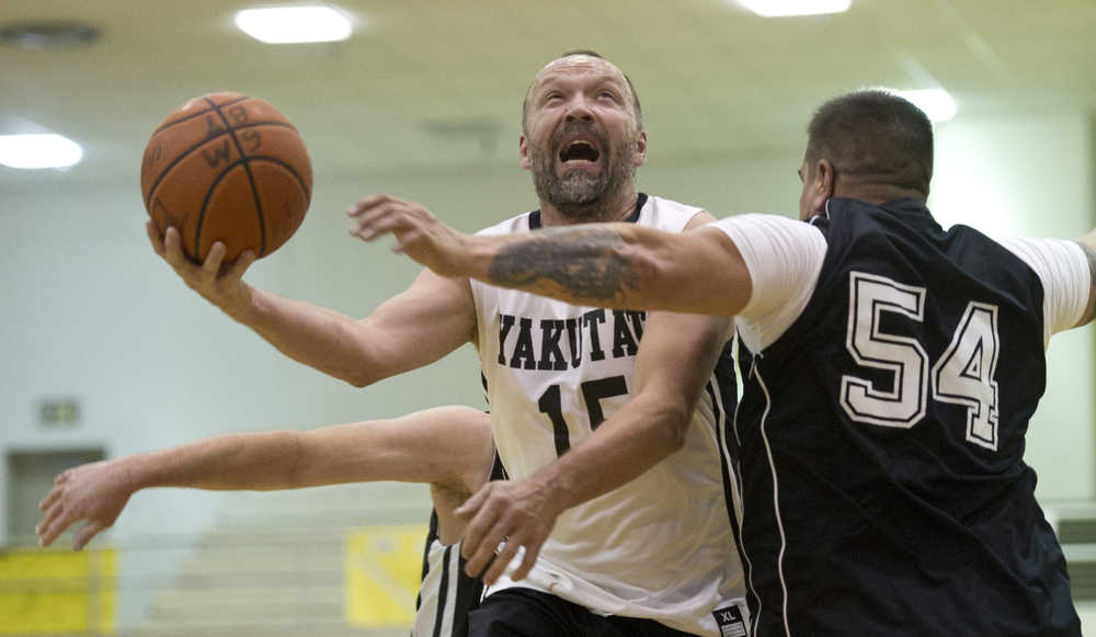 Yakutat's Greg Indreland drives to the basket against Klukwan's Danny Thomas during their Masters bracket game in the 2016 Juneau Lions Club 70th Gold Medal Basketball Tournament at Juneau-Douglas High School on Wednesday.
