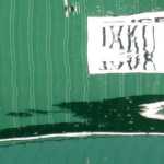 The side of a downtown icehouse reflects in harbor waters on a windy day, creating a wavy abstract. Photo by Denise Carroll.