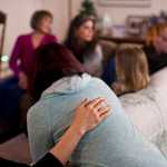 Director Kara Nelson, left, offers her support to resident Daricka Clark after a group dinner at Haven House on Tuesday. Haven House is celebrating its one-year anniversary as a transitional home for recently released female prisoners and women coming out of substance abuse or mental health treatment.