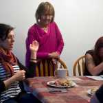 Haven House Director Kara Nelson, left, leads a prayer at a group dinner on Tuesday. Also shown are Board Chair June Degnan, center, and resident Andrea Robinson. Haven House is celebrating its one-year anniversary as a transitional home for recently released female prisoners and women coming out of substance abuse or mental health treatment.