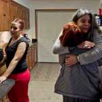 House manager Julee Douglas gives a former resident a hug as current resident Andrea Robinson, left, prepares a group dinner at Haven House on Tuesday. Haven House is celebrating its one-year anniversary as a transitional home for recently released female prisoners and women coming out of substance abuse or mental health treatment.