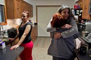 House manager Julee Douglas gives a former resident a hug as current resident Andrea Robinson, left, prepares a group dinner at Haven House on Tuesday. Haven House is celebrating its one-year anniversary as a transitional home for recently released female prisoners and women coming out of substance abuse or mental health treatment.