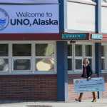 IMAGE DISTRIBUTED FOR MATTEL, UNO - Amy Skilbred, Executive Director of the Juneau Community Foundation, walks away from Juneau, Alaska's City Hall with a $15,000 check presented to her by Mattel on Friday, April 1, 2016. As part of an April Fools' promotion, the city of Juneau and Mattel announced a renaming of Juneau to UNO. (Michael Penn/AP Images for Mattel, UNO)