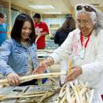 Tlingit elder Helen Watkins helps freshman Charity Lumba move shaved Devil's Club stocks as she teaches students how to make an ointment at Yaakoosge Daakahidi Alternative High School in April 2015.