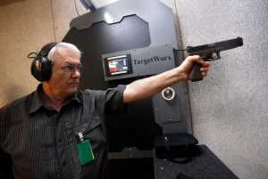 In this March 11 photo, Dr. Michael Victoroff, a physician in the Denver area whose leisure-time passion is competitive shooting, practices at a range in Centennial, Colorado.