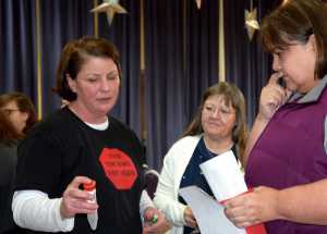 Michele Stuart Morgan, far left, shows Juneau residents at the "Hope, Not Heroin" event Saturday inside the Juneau Arts & Culture Center how to use medical waste containers on the go in case they come across syringes in the community. The tubes were purchased by the City and Borough of Juneau, and the organization "Stop Heroin, Start Talking" is helping to distribute them for free.