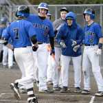 Thunder Mountain players gather around home plate to celebrate Finn Collins' (7) two-run home run in the first inning of the Falcons' 5-8 loss to Ketchikan High School at Norman Walker Field.