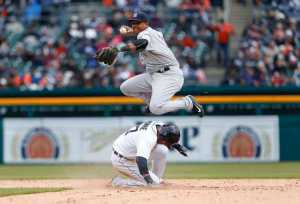 Detroit Tigers' Andrew Romine slides safely into second base as New York Yankees second baseman Starlin Castro throws to first base on a James MCann ground ball in the eighth inning Friday in Detroit. Romine was originally called out on the play but was overturned on video replay.