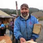 Owen James, who is carving panels and poles for the tribal house in Glacier Bay, holds a handful of wood chips with names on them, all of which were removed from the canoe being steamed open. Community members wrote the names of friends and family members affected by drugs, alcohol, abuse, or other forms of trauma and burned those chips as a symbolic cleansing as the canoe was being steamed open.