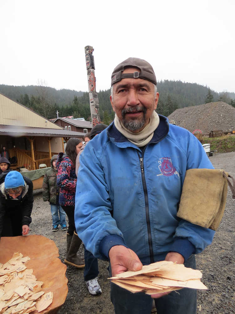 Owen James, who is carving panels and poles for the tribal house in Glacier Bay, holds a handful of wood chips with names on them, all of which were removed from the canoe being steamed open. Community members wrote the names of friends and family members affected by drugs, alcohol, abuse, or other forms of trauma and burned those chips as a symbolic cleansing as the canoe was being steamed open.