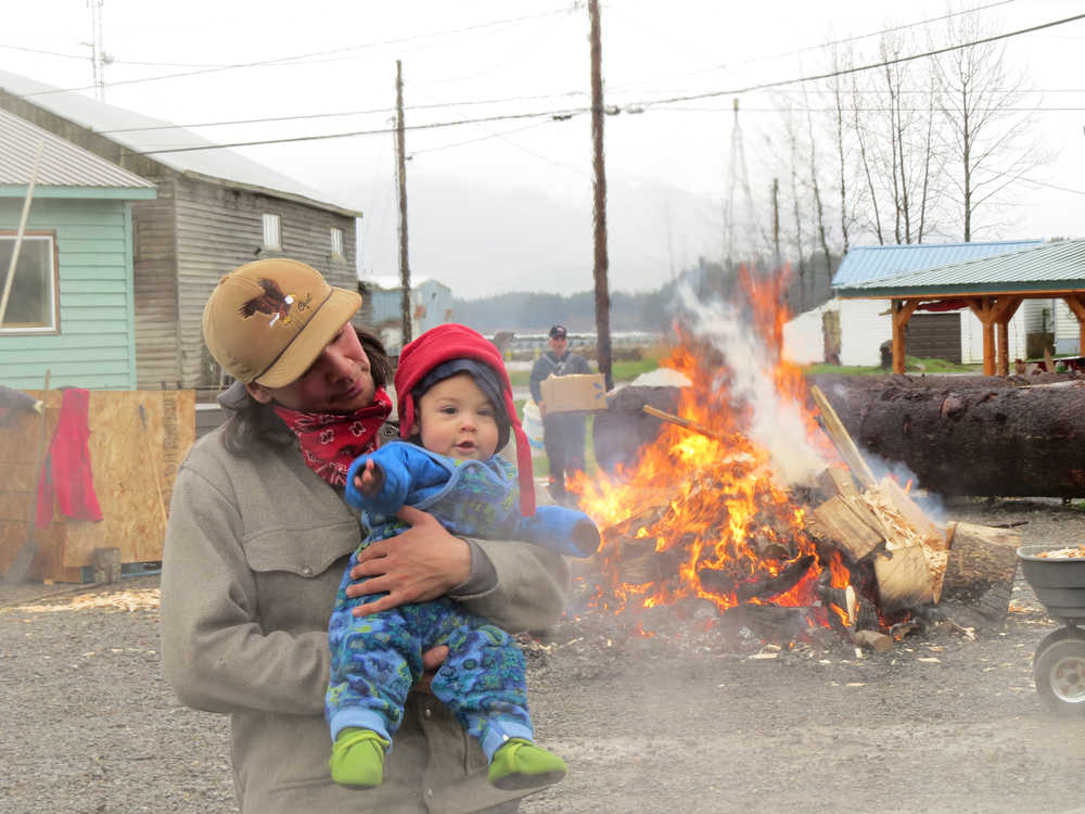 Ted and Adze Hart, who is seven months old, watch as the canoe is steamed. Ted is brother to apprentice James Hart, and came down from Haines with Meghan Elliott to participate in the final week of carving and the steaming. Adze danced and offered moral support as community members and carvers drummed.