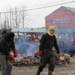 James Hart and Zack James carry heated rocks from the fire to the canoe.