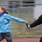 Sophmore Mikayla May, left, and senior Eva Tompkins practice their baton handoff during the Thunder Mountain High School track practice on Tuesday.