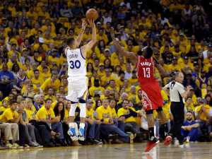 Golden State Warriors' Stephen Curry makes a 3-point basket over Houston Rockets' James Harden during Game 1 on Saturday.