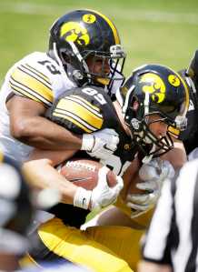 Iowa wide receiver Matt VandeBerg is tackled by defensive back Miles Taylor, left, after making a reception during the team's NCAA college football spring game, Saturday, April 23, 2016, in Iowa City, Iowa. (AP Photo/Charlie Neibergall)