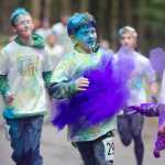 A runner makes his way through the purple station toward the finish line during Sunday's Runners celebrate their success by throwing many different colors up in the air during Sunday's Raining Colors 5K Fun Run. Proceeds benefit the Juneau Youth Triathlon Club..
