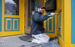 Woody Collins touches up the paint on the Effy Jewelers on South Franklin Street on Tuesday. The first cruise ship of the season arrives on Saturday, April 30.