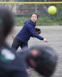Senior Samanta Pak warms up with a teammate during Juneau-Douglas girls softball practice at Melvin Park on Tuesday.