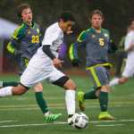 Juneau-Douglas' Sherrod Miller makes an attempt to score against Service's Dorian Cornichuck, left, and Quinn Harris during their game at Adair Kennedy Memorial Park on Friday.