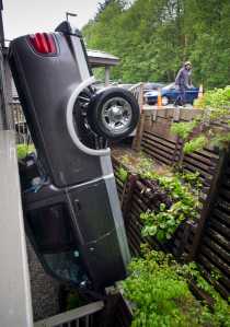 The driver, who did not wish to be identified, walks by his upended truck at the Westridge Condominiums on Hermit Street in downtown Juneau on Friday. The driver was unhurt in the accident that happened about noon on Friday. The driver, with a construction company working at the condominiums, said his brakes failed to work.