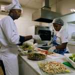 In this May 6 photo, cooks prepare meals during one of many food-testing exercises of the Olympic menu in Rio de Janeiro, Brazil. Diners will choose from five different buffets: Brazilian, Asian, International, Pasta and Pizza, Halal and Kosher, and everyone gets to dig into 40 varieties of Brazil's exotic fruits like caju, acai, carambola, caqui, goiaba and maracuja.