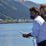 Former Juneau Chamber of Commerce President Lance Stevens, front, and other tour passengers look across the channel at Bridge Park, the future site of the bronze whale sculpture on Thursday.