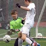 In this May 2014 file photo, Thunder Mountain keeper John Seymour attempts to block a shot by a Juneau-Douglas player. Seymour, now a senior, will play soccer at Edmunds Community College in the fall.