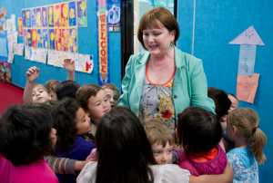 Mendenhall River Commuity School Principal Kathryn Milliron is surrounded by students as she walks the school's hallway on Friday. Milliron is retiring in June.