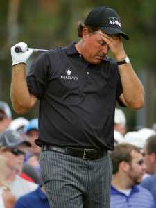FILE - In this June 12, 2014, file photo, Phil Mickelson, right, reacts to his tee shot on the eighth hole during the first round of the U.S. Open golf tournament in Pinehurst, N.C. The Securities And Exchange Commission is filing a complaint against Mickelson related to insider trading. The SEC says, in 2012 high-profile sports bettor Billy Walters called Mickelson, who owed him money, and urged him to trade Dean Foods stock. The SEC says Mickelson did so the next day and made a profit of $931,000.  The SEC says Walters received tips and business information about Dean Foods Co. from former Dean Foods director Thomas Davis between 2008 and 2012. (AP Photo/Matt York, File)