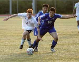 Ketchikan High School sophomore Max Collins (21) and a Thunder Mountain defender run after the ball Friday, May 20, 2016, during the Kings' 5-0 win against the Falcons at Esther Shea Field.