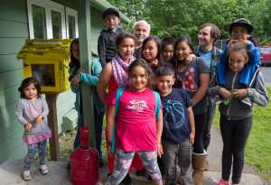 Jim Fowler, back center, poses with children next to a small library they decorated at the Geneva Woods housing complex Wednesday. Fowler has been helping youth with art projects since 1998.