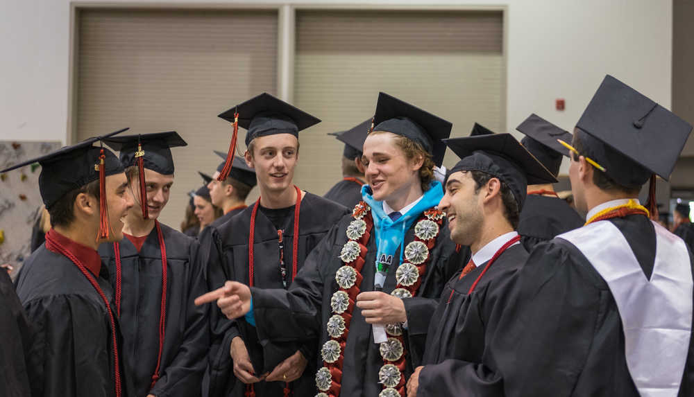Hunter Pegues, center, Oscar Jones, left, and Chase Barnum, right, talk to classmates before the graduation ceremony Sunday at Juneau-Douglas High School.