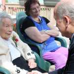 Lorraine Osbourn receives a birthday greeting from Alaska Gov. Bill Walker on Tuesday during a celebration at The Bridge Adult Day Program run by Catholic Community Service.