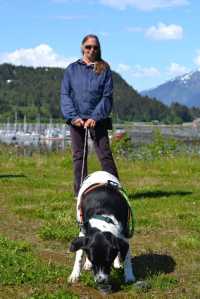 Haines resident Carrie Kinison, owner of  bedbug detection service Auggie Doggie, stands with her dog Harvey as he eats a snack. Kinison has spent years training Harvey to sniff out bedbugs.