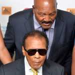 FILE - In this Sept. 27, 2014, file photo, Jim Brown, rear, whispers a message to Muhammad Ali during their meeting before the Ali Humanitarian Awards ceremony, in Louisville, Ky. The message that Brown whispered was "You're the greatest of all time," Brown later told a reporter. Ali, the magnificent heavyweight champion whose fast fists and irrepressible personality transcended sports and captivated the world, has died according to a statement released by his family Friday, June 3, 2016. He was 74.  (AP Photo/Timothy D. Easley, File)