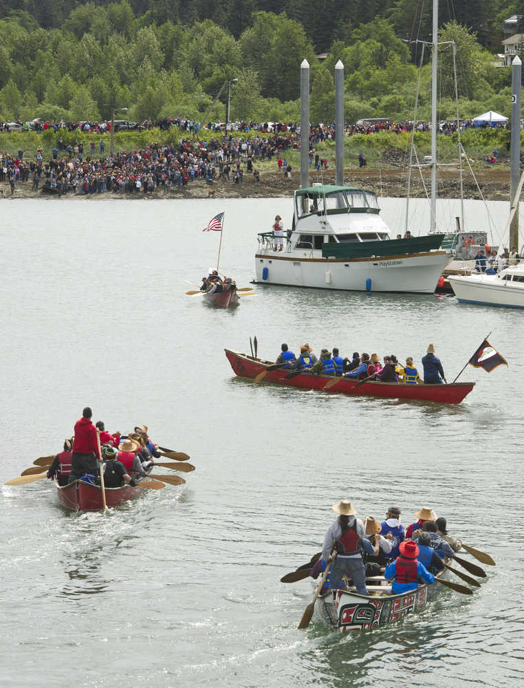Canoes enter Douglas Harbor for the Coming Ashore Ceremony sponsored by the One People Canoe Society on Wednesday.