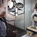 An art show attendee on Wednesday looks at Clarissa Rizal's "Chilkat Child" and Lily Hope's "Chilkat Seasons Dance Apron." Sealaska Heritage Institute's Northwest Coast Juried Art Show will be on display in the Walter Soboleff Building through Sep. 30.