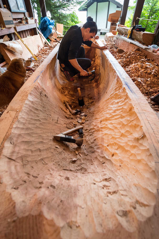 Haida carver TJ Young works on yellow cedar canoe last week in Sitka.