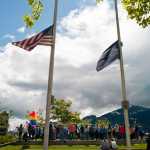 Flags fly at half-staff as Juneau residents attend a noon vigil Monday at Marine Park for the victims of the Orlando shootings over the weekend.