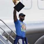 Cleveland Cavaliers' LeBron James raises the NBA Championship trophy after arriving at the airport, Monday, June 20, 2016, in Cleveland. (AP Photo/Tony Dejak)